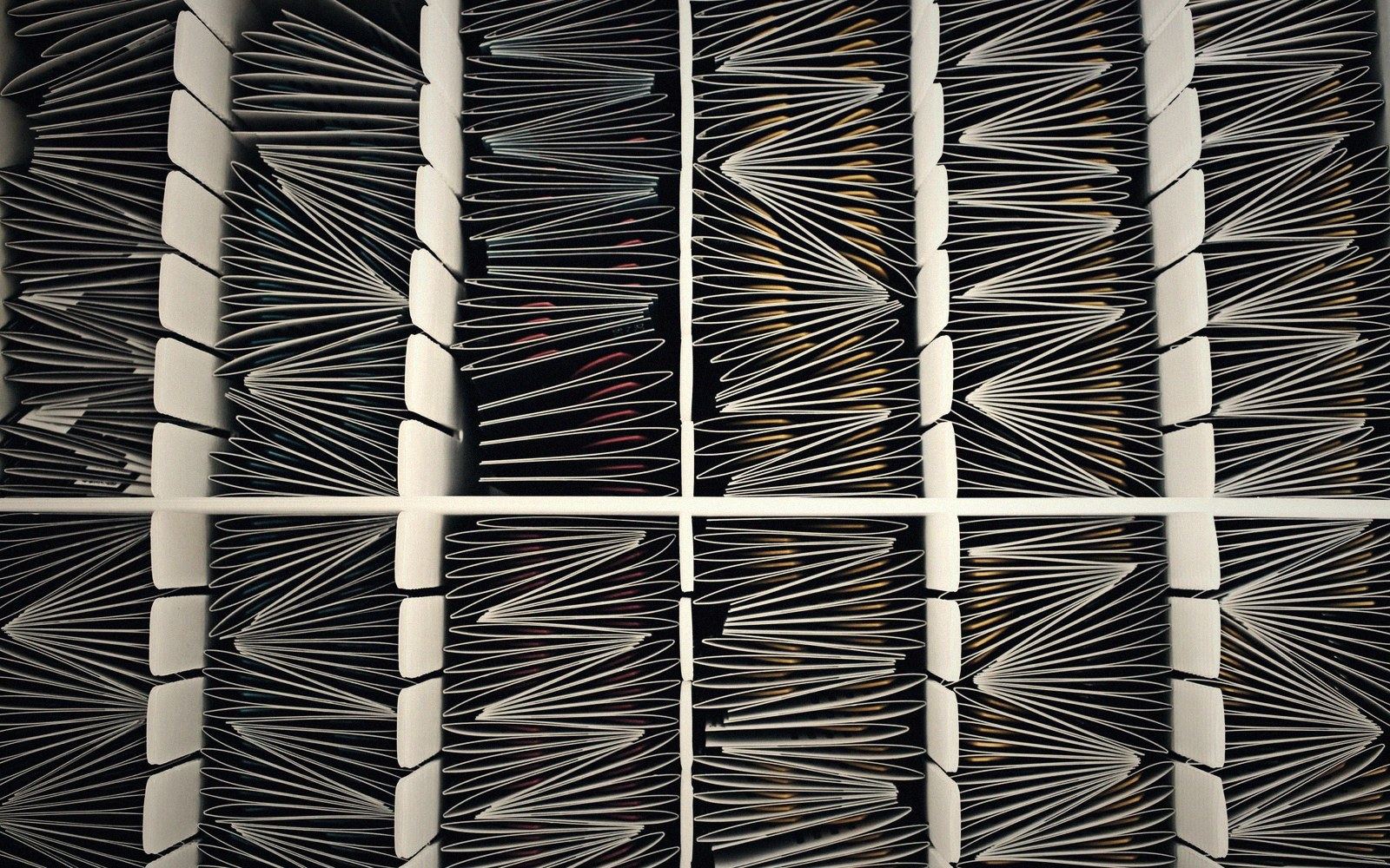 Rows of accordion-folded panels create repeating fan-shaped pleats across a divided surface