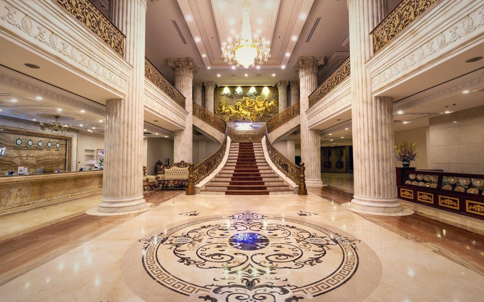 Hotel lobby colonnade at night, terrazzo floor reflecting lamp light, no guests present