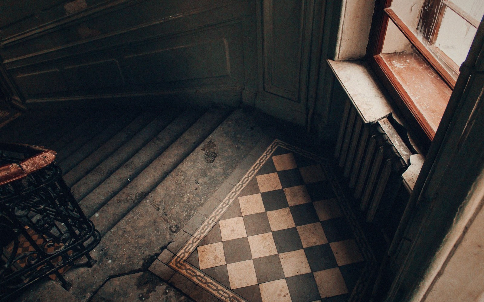 Close detail of a cast-iron or brass stair rail in a historic hotel, worn finish visible